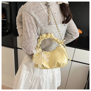 Détail du sac nuage froncé jaune clair avec nœud en dentelle blanche et chaîne en perles