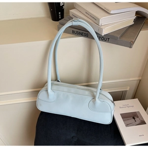 Close-up of light blue minimalist shoulder bag with long handle on aesthetic background