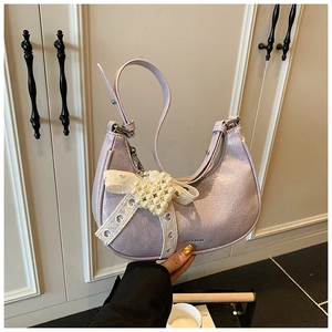 Detail of lavender pleated crescent bag with delicate lace bow and pearl embellishment