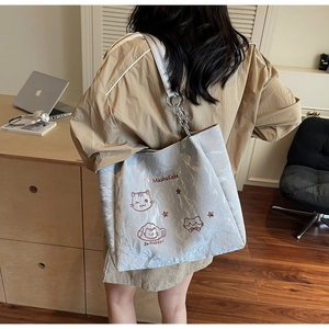 Détail du sac cabas plissé argenté avec broderie chat et bandoulière en chaîne