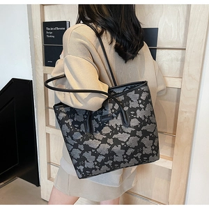Detailed back view of a large geometric pattern tote bag on person for size reference