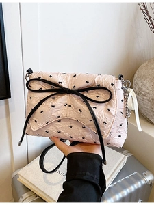 Borsa a bauletto rosa con trama a bolle, stampe a fiocco nero e grande fiocco decorativo