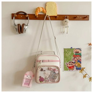 Detailed view of the transparent Ita bag window with cute anime pins and charms