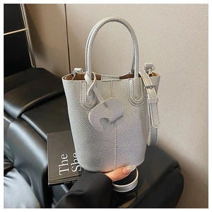 Silver pebbled leather bucket bag featuring a sleek handle and leather elephant charm