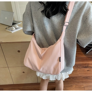 Detail view of pink nylon hobo bag showing the soft draped texture and wide shoulder strap