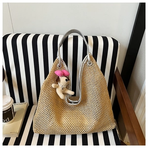Detail showing woven straw texture and silver handle with cute plush puppy charm