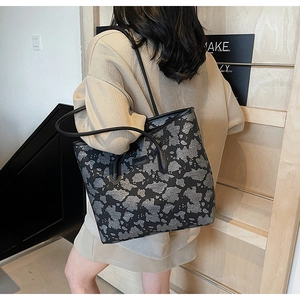 Detail of a large capacity tote bag with cloud print pattern and leather shoulder straps