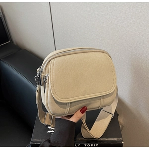 Detailweergave van de beige canvas crossbodytas met meerdere vakken en een brede schouderriem