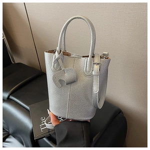 Detail of silver bucket bag with lychee texture and cute elephant charm pendant