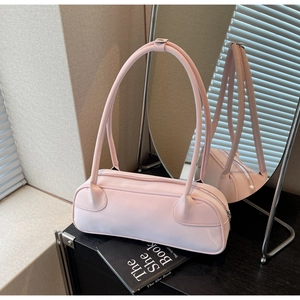 Detail view of pink cylinder shoulder bag with unique tube handles and silver metal zipper