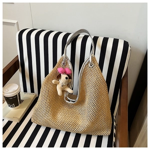 Detailed straw tote bag texture with silver handles and cute puppy charm on striped background