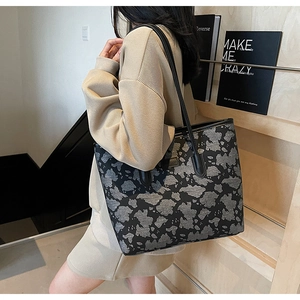 Detail of a large capacity tote bag with grey camo pattern shown in a modern interior