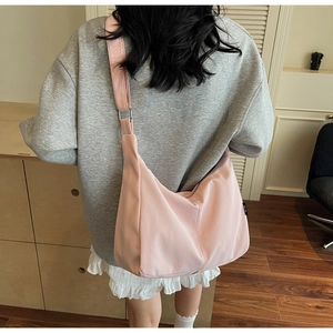 Close-up of pink oversized crescent canvas shoulder bag with adjustable wide strap