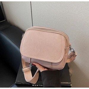 Detail van roze crossbodytas met dubbele ritssluiting en verstelbare schouderband