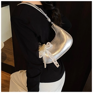 Detail view of silver crescent bag with metallic crinkled texture and pearl lace bow