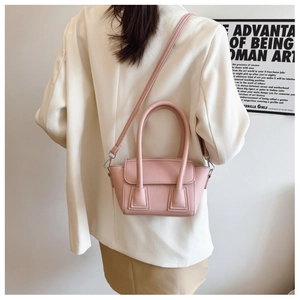 Detail of pink lychee pattern bucket bag with double handles shown on a model