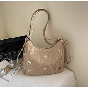 Detail of apricot pleated shoulder bag with metal butterflies and adjustable strap
