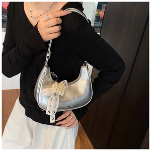 Detail of silver metallic hobo bag with pleated texture and pearl lace bow charm