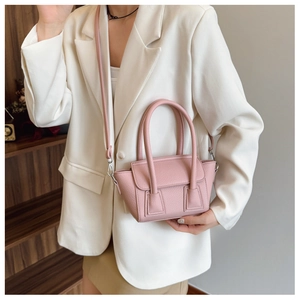 Detailed close-up of pink lychee textured leather tote bag with crossbody strap