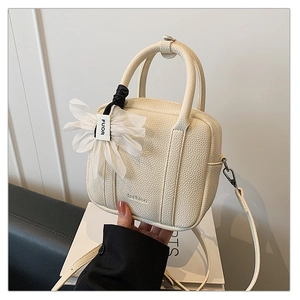 Macro shot of off-white Boston bag with litchi texture and fashion embossed detail