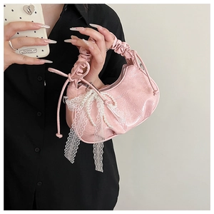 Vue détaillée du sac croissant plissé rose avec nœuds en dentelle et perles