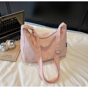 Detail of pink nylon dumpling bag with adjustable strap and silver metal buckle