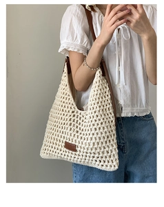 Dettaglio della borsa tote beige all'uncinetto con tracolla in pelle marrone