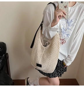 Close-up of beige hollow knit shoulder bag with adjustable brown leather strap detail