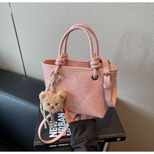 Detail of pink pleated leather mini bucket bag with bear pendant and logo embossing