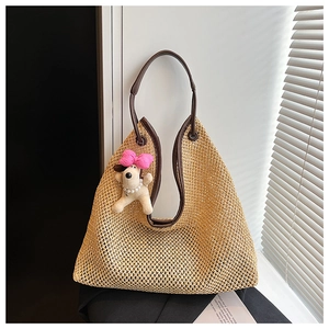 Detail of hand-woven straw tote texture with brown leather strap and puppy charm