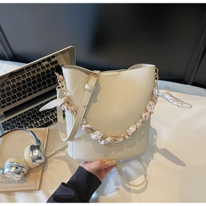 Détail du sac seau blanc crème avec cuir grainé et foulard en soie à imprimé cœur