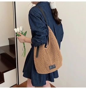 Detail of khaki crochet woven tote bag with leather strap shown in lifestyle scene