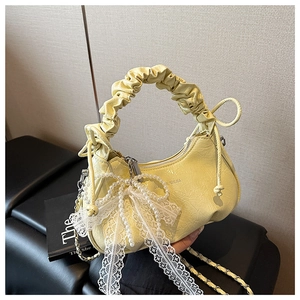 Détail du sac croissant jaune clair avec poignée nuage, nœud en dentelle et perles