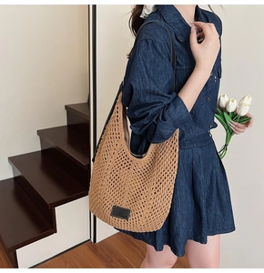 Detail of hollow crochet woven shoulder bag with leather patch and slender black strap