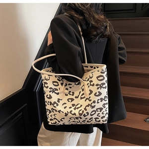 Detail of a leopard print leather tote bag showing fine texture and sleek shoulder straps