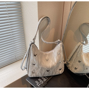 Close-up of hobo bag featuring crinkle texture and silver butterfly metal ornaments