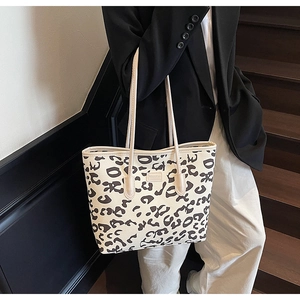 Detail of a large leopard print canvas tote bag with slim shoulder straps for daily commute