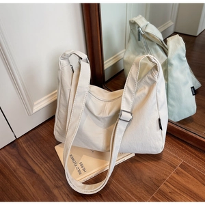 Detail view of beige canvas crescent bag with adjustable strap and silver metal buckle