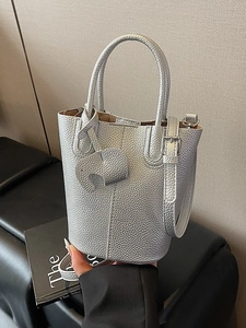 Silver metallic leather bucket bag with litchi texture and elephant charm accessory