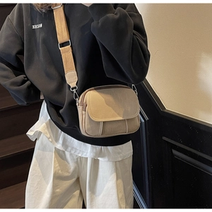 Detailweergave van de kaki canvas crossbodytas met een brede verstelbare schouderriem