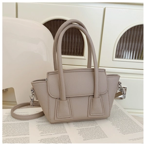 Close-up of a light brown lychee textured tote bag featuring silver metal hardware details