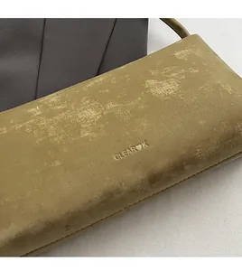 Close-up of olive green matte leather shoulder bag with embossed logo texture detail