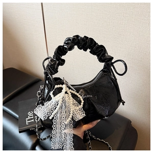 Détail du sac hobo croissant noir avec nœud en dentelle et breloque en perles