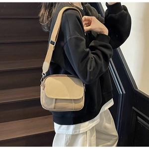 Beige canvas crossbodytas met verstelbare brede stoffen band gedragen door model