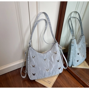 Close-up of a silver pleated shoulder bag featuring elegant metallic butterfly accents