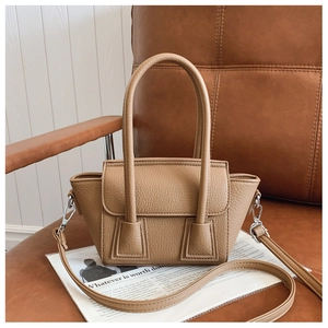 Detailed view of brown litchi grain leather texture on a stylish bucket handbag