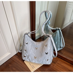 Detailed close-up of metallic silver shoulder bag with 3D butterfly metal ornaments