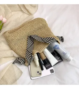 Ampia borsa tote in paglia intrecciata che mostra l'interno per tablet e trucchi