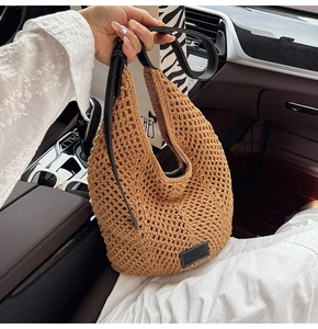 Detail of hollow woven texture and black leather handle on the shoulder bag