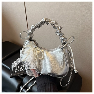 Détail du sac croissant métallisé avec nœud en perles, dentelle et poignée froncée